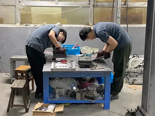 Two technicians in the mold workshop repairing molds.