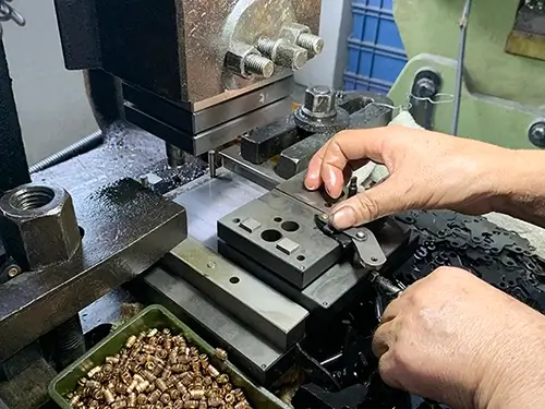 A close-up image of a manual riveting machine in operation