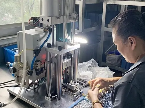 A female employee using a pneumatic riveting machine for riveting work