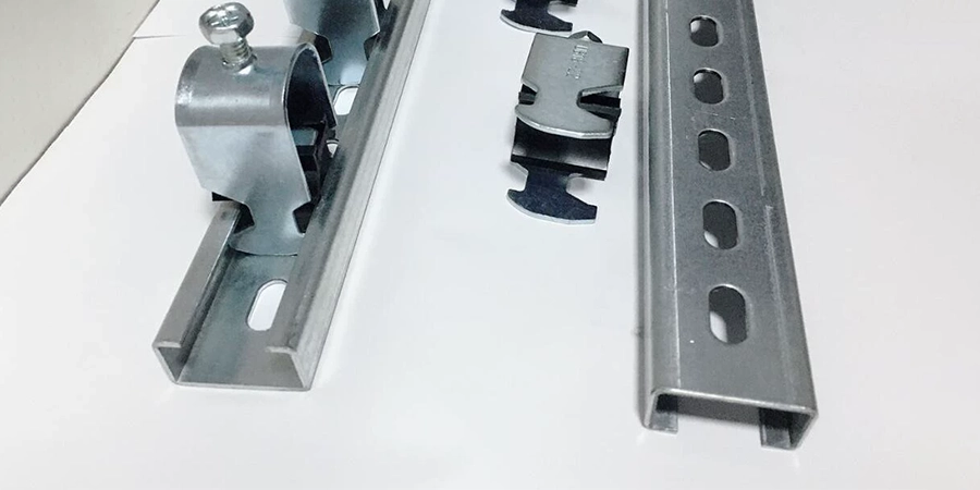 A silver metal strip with slotted holes, fitted with clamps and additional clamping components.