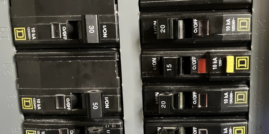A close-up view of an electrical panel containing multiple black GFCI breakers with labels from Square D. The breakers are rated at 10 kA and 120/240V, with amperage settings of 15A, 20A, 30A, and 50A. Some switches are in the