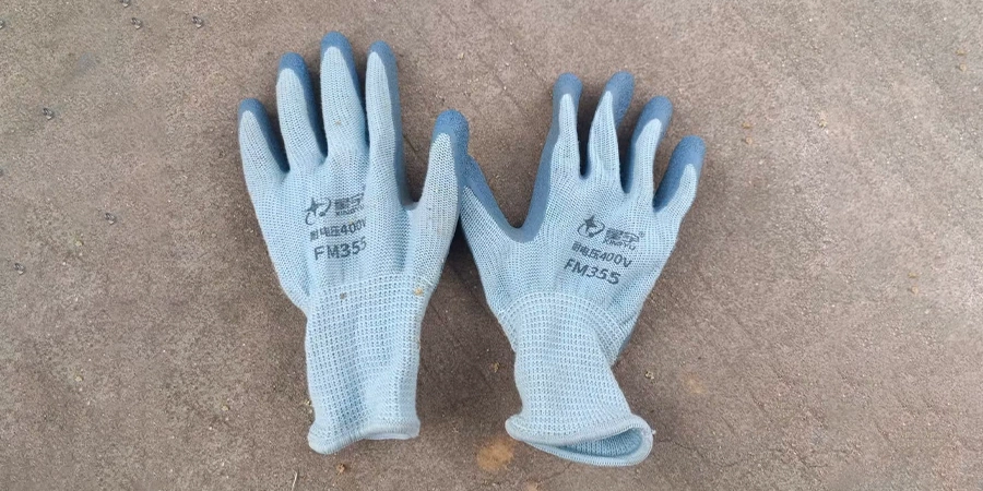 A pair of light gray insulated safety gloves labeled