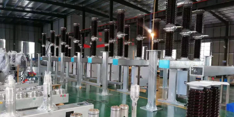 A photograph of a modern industrial manufacturing facility showcasing a production line of SF6 circuit breakers. The line features multiple tall, metallic structures with stacked black and silver insulators and components, arranged in rows under a high-ceilinged warehouse with a metal roof. Various stages of assembly are visible, with some units equipped with control panels and others in progress. The floor is clean with green markings, and additional equipment and materials are scattered around, indicating an active production environment for high-voltage electrical devices.