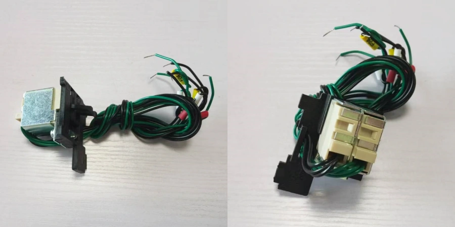 A split-view image of auxiliary contacts for a Molded Case Circuit Breaker (MCCB), showing two perspectives on a light wood surface. On the left, a black plastic module with a silver rectangular coil and multiple colored wires (green, yellow, red, and black) extending from it. On the right, a beige terminal block with gold contacts, connected to similar green wires and a black connector, used for signaling and control in electrical panels.