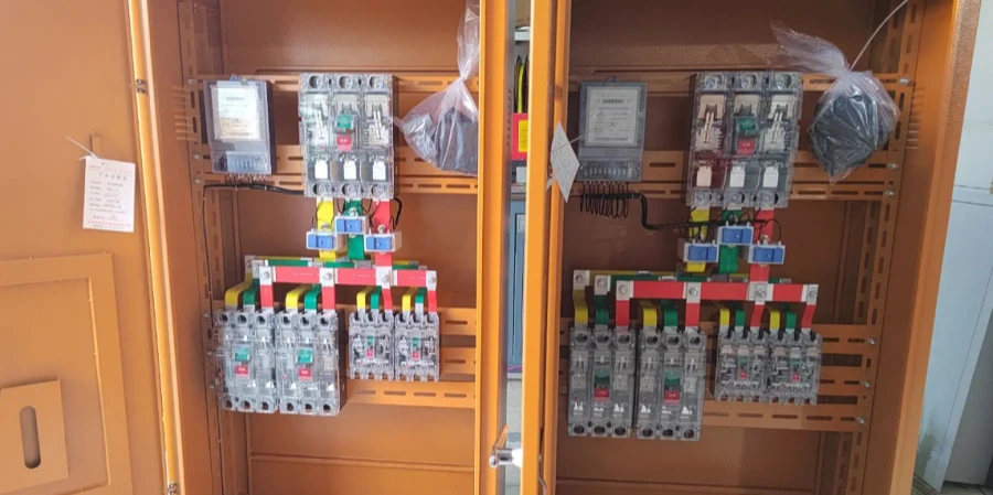 Two orange metal cabinets side by side, each containing rows of gray MCCBs and contactors connected to colorful busbars, with digital meters on top and protective plastic bags over some parts.