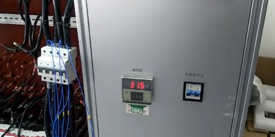 A metal test panel running a temperature rise test on a miniature circuit breaker (MCB). The MCB is connected with thick blue cables, with Chinese labels indicating the temperature monitoring zone and overload switch.