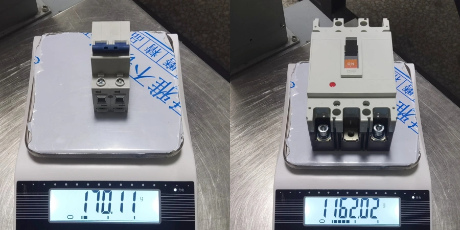 A 2-pole miniature circuit breaker (MCB) weighing 170.11g on the left digital scale next to a much larger 3-pole 100A frame molded case circuit breaker (MCCB) weighing 1162.02g on the right, clearly showing the size and weight difference between the two types of breakers.