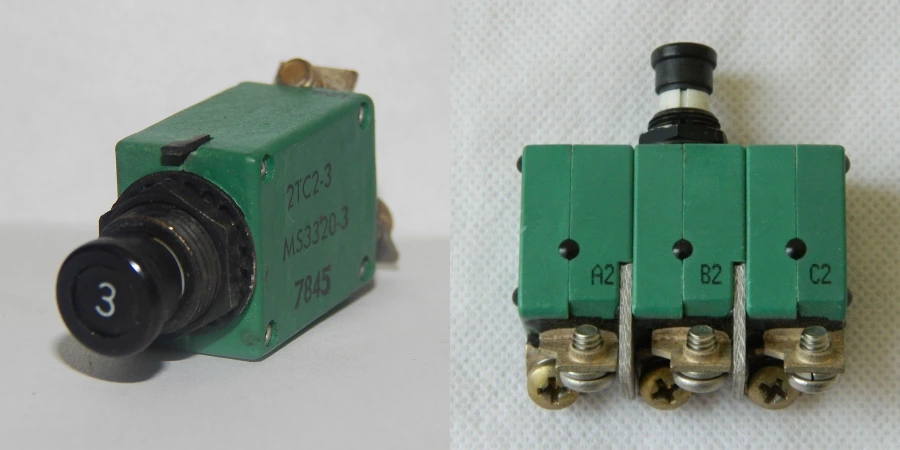 Two green military/aerospace circuit breakers on a white background: left is a single-pole 3-amp breaker marked “3”, “2TC2-3”, “MS3320-3”, and “7845”; right is a three-pole version with terminals labeled A2, B2, C2.