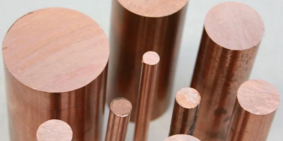 A group of cylindrical tungsten-copper alloy rods of different diameters and lengths arranged on a white background. The metal has a shiny reddish-brown copper color with a smooth machined surface, showing the material commonly used for electrical contacts and heat sinks.