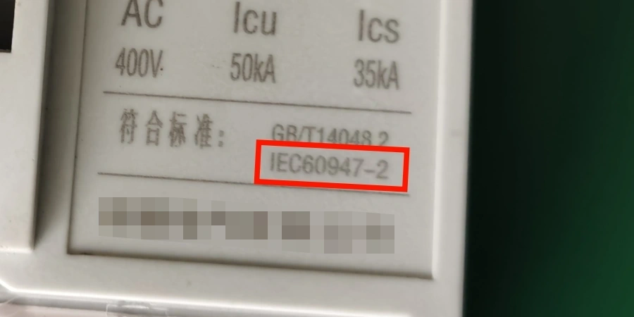 Close-up of the front label on a white or light gray molded case circuit breaker (MCCB), displaying AC voltage rating '400V', ultimate breaking capacity 'Icu 50kA', service breaking capacity 'Ics 35kA', and compliance standards listed as 'GB/T 14048.2' and 'IEC 60947-2' (with IEC 60947-2 highlighted in a red box), printed in black text, typical specifications found on low-voltage industrial or commercial circuit breakers for electrical protection.