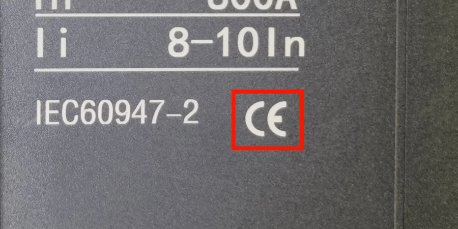 Close-up of a dark gray MCCB label showing the CE conformity mark highlighted in a red box, along with 'IEC 60947-2' standard compliance.