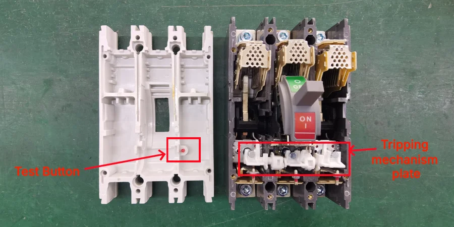 Side-by-side view of a disassembled molded case circuit breaker on a green surface. Left side shows the white plastic housing with a small red-circled test button. Right side shows the internal mechanism with a red-circled tripping mechanism plate, ON/OFF handle, and various metal and plastic components.